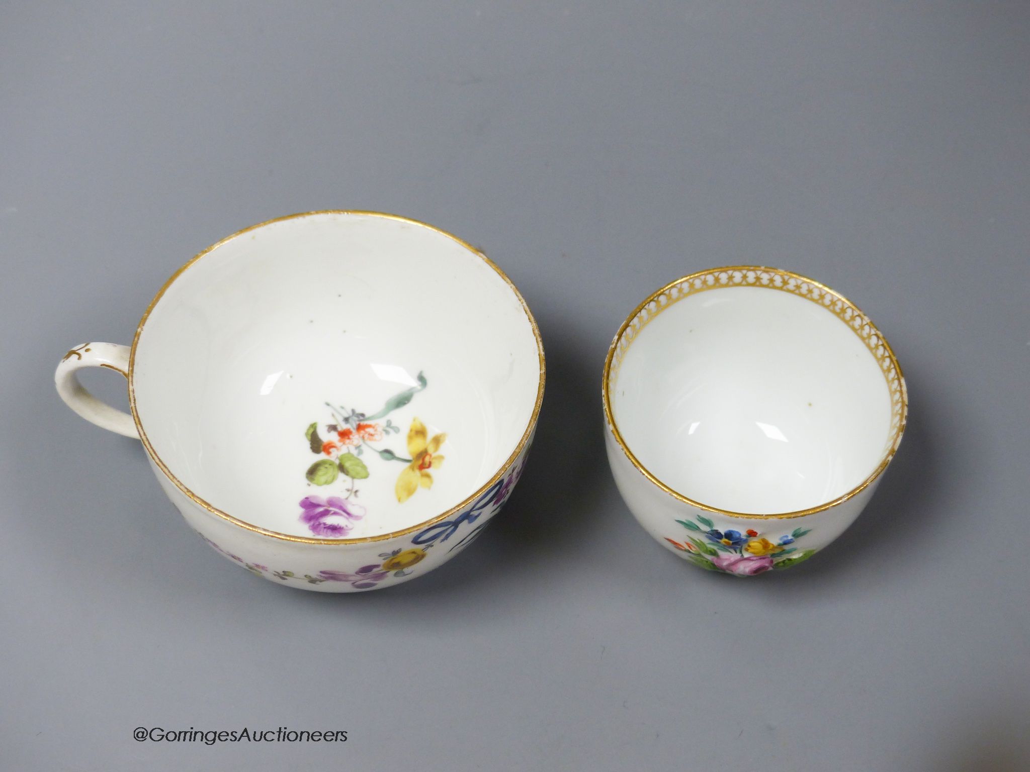 A Meissen bowl, c.1750, moulded and painted with flowers, 6cm diameter and Meissen cup, c.1750 painted with a parrot and flowers (2)